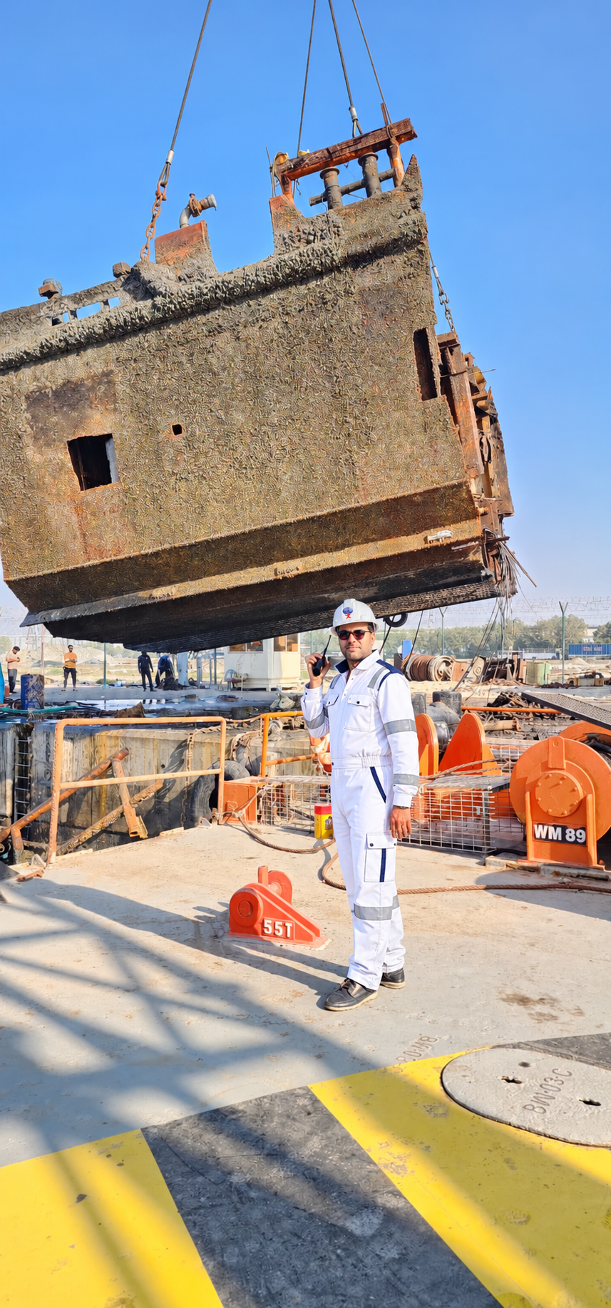 Fourteen Universe team member in white PPE during a shore-side wreck removal operation